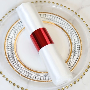 Close-up of a glossy red metal napkin ring on a white satin napkin for wedding decor