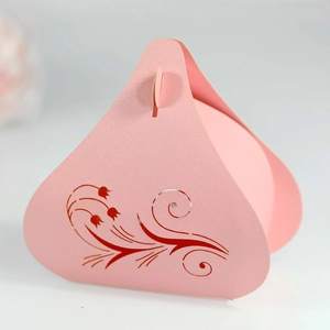 Macro shot of laser-cut tulip patterns on a pink pearl paper wedding candy gift box