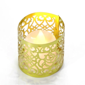 Dettaglio dei motivi a rose e cuori intagliati sul portacandele in metallo LED oro