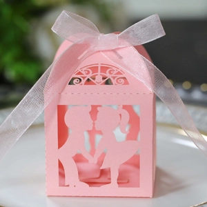 Détail de la boîte à bonbons rose découpée au laser avec silhouette de couple et ruban blanc