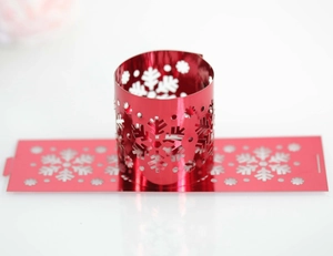 Detail of red metallic snowflake napkin rings with laser-cut hollow pattern for holidays