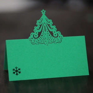 Detail of laser-cut Christmas tree place card in emerald green with snowflake design