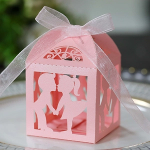 Boîte à bonbons rose découpée au laser avec silhouette garçon et fille et nœud blanc