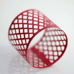 Macro view of a red laser-cut napkin ring with a geometric diamond mesh pattern