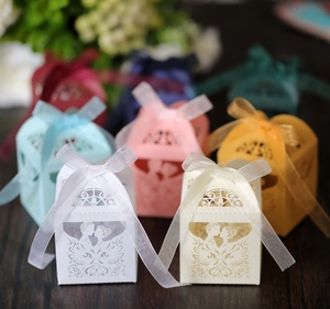 Makro-Detail der lasergeschnittenen Hochzeitsbox mit küssendem Paar und Organza-Schleife