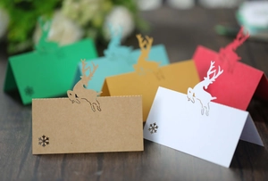 Close-up of reindeer hollow-out Christmas place cards with snowflake details on wood background