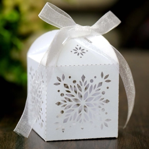Detailed laser-cut white snowflake favor box with elegant white organza ribbon bow