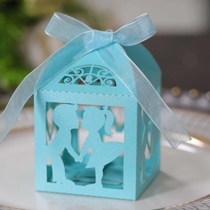 Boîte cadeau ajourée bleu ciel avec silhouettes romantiques et ruban en organza