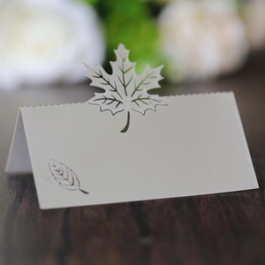 Laser-cut white place card with maple leaf design for wedding or banquet table settings