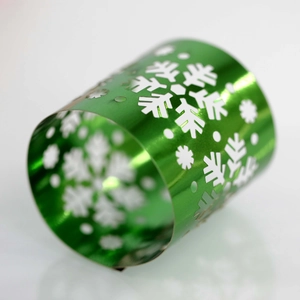 Close-up of green metal snowflake napkin ring with intricate cutout holiday design