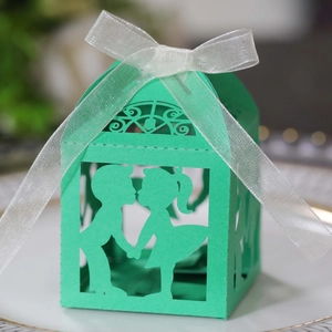 Détail boîte à bonbons vert menthe découpée au laser avec silhouette et ruban blanc