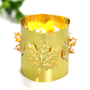 Detail of golden metal hollow maple leaf paper lamp shade with warm LED light glow