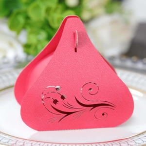 Detail of pink laser-cut tulip candy box in pyramid shape on a white ceramic tray