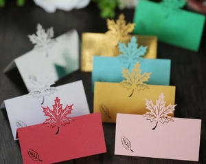 Close-up of laser-cut maple leaf place cards in various vibrant pearlescent colors
