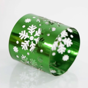 Detail of green laser-cut metal napkin ring with hollow snowflake patterns