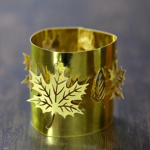 Close-up of golden hollow maple leaf candle shade with intricate laser-cut patterns