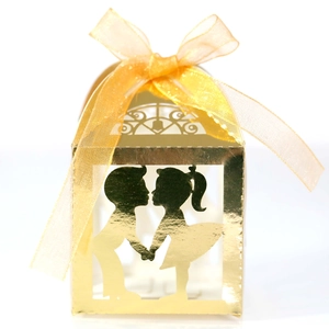 Détail boîte à bonbons dorée découpée au laser avec silhouette garçon et fille creuse