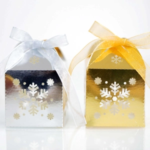 Detalle de cajas de regalo plateadas y doradas con copos de nieve y lazos de organza