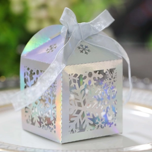Détail de la boîte cadeau flocon découpée au laser avec ruban bleu sur assiette