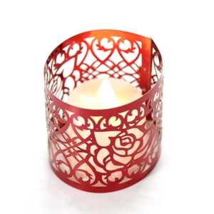Dettaglio del portacandele in metallo rosso intagliato al laser con rose, cuori e LED