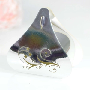 Close-up of holographic silver triangle gift box with intricate golden floral patterns