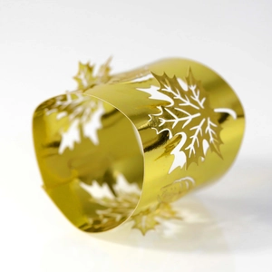 Detail showing laser-cut gold maple leaf napkin ring with polished metal finish