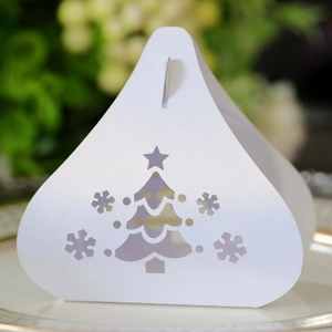 Macro shot of laser-cut Christmas tree and snowflake patterns on white cardbox