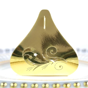 Macro view of laser-cut tulip candy box in shimmering gold paper for weddings