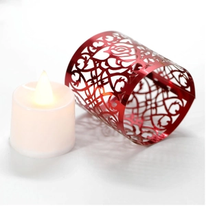 Dettaglio del copricandela rosso tagliato al laser con motivi di rose e cuori su LED