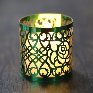 Dettaglio del paralume verde con motivo a rose traforate e luce calda a candela LED