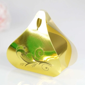 Close-up of golden pyramid candy box with floral patterns and heart-shaped cutout