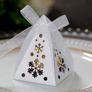 Detail van witte piramide snoepdoos met goud en zilver sneeuwvlokken en lint