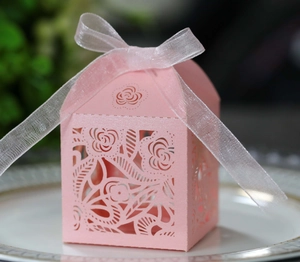 Close-up of laser-cut rose hollow favor box in pink cardstock with white organza ribbon