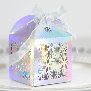 Détail boîte cadeau irisée avec découpe laser flocon de neige et ruban gris soyeux
