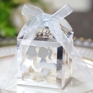 Détail macro d'une boîte cadeau argentée découpée au laser avec silhouette et ruban organza