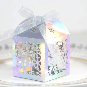Gros plan d'une boîte cadeau holographique flocon de neige avec ruban argenté sur plat