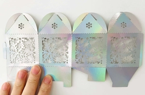Vue détaillée de la boîte à bonbons holographique découpée au laser avec motifs de flocons
