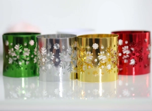Detailed view of hollow snowflake napkin rings in gold, silver, red, and green metallic finish