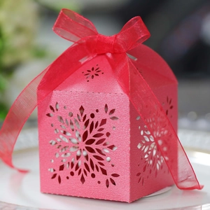 Close-up of pink laser-cut snowflake candy box with elegant organza ribbon bow