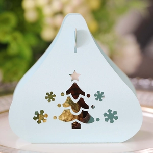 Detail of light blue laser-cut Christmas candy box with snowflake and tree patterns