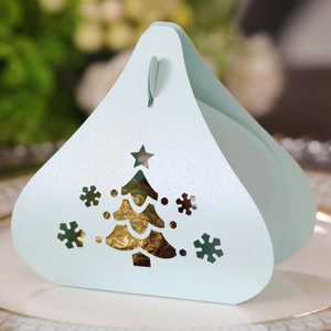 Detailed laser-cut Christmas tree and snowflake patterns on a light blue candy box