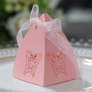 Detailed macro view of a pink pyramid wedding gift box with laser-cut butterfly patterns