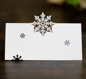 Macro view of laser-cut snowflake place card in white pearlescent paper for Christmas