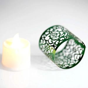 Dettaglio del motivo a rose tagliato al laser su involucro decorativo verde scuro