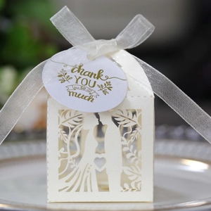 Detail of laser-cut wedding favor box with romantic silhouette and thank you tag