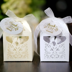 Detail der lasergeschnittenen Hochzeits-Gastgeschenke mit Kuss-Motiv und Schleife
