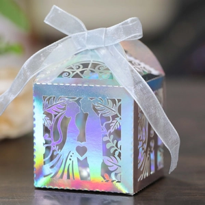 Macro shot of laser-cut wedding candy box with iridescent finish and ribbon detail