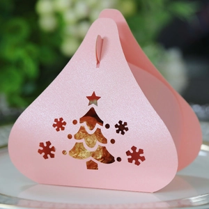 Macro shot of pink laser-cut Christmas tree candy box with sparkling pearlescent paper