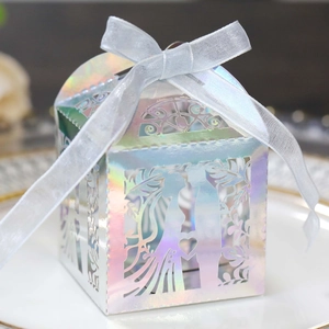 Close-up of laser-cut hollow candy box with iridescent paper and satin ribbon bow