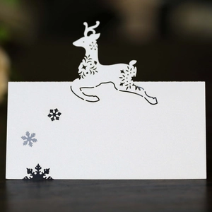Detailed laser-cut white pearl paper place card featuring a reindeer and snowflake patterns